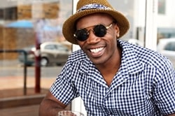 Photo of an African-American man wearing a hat and sunglasses
