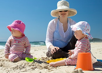 Photo of a woman and her children wearing hats and long sleeved shirts