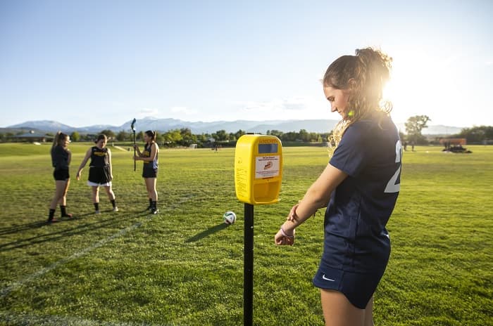 Katelyn Rovig uses a sunscreen dispenser before heading to practice