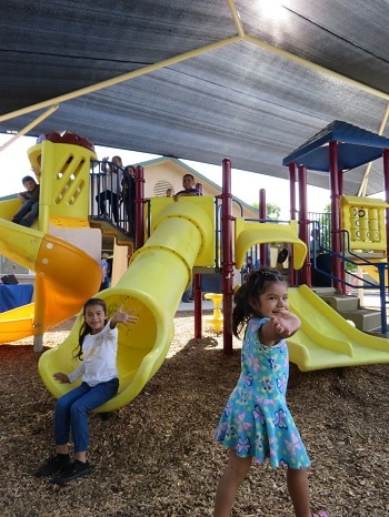 Children play under a shade structure funded by the American Academy of Dermatology.