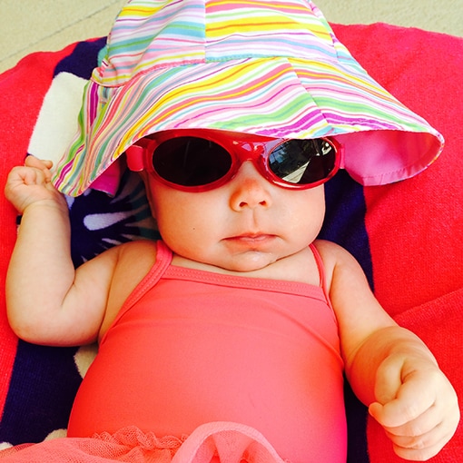Baby keeping it cool with a wide-brimmed hat and shades.