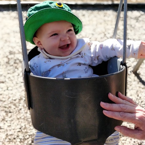 Baby staying sun-safe in a swing.