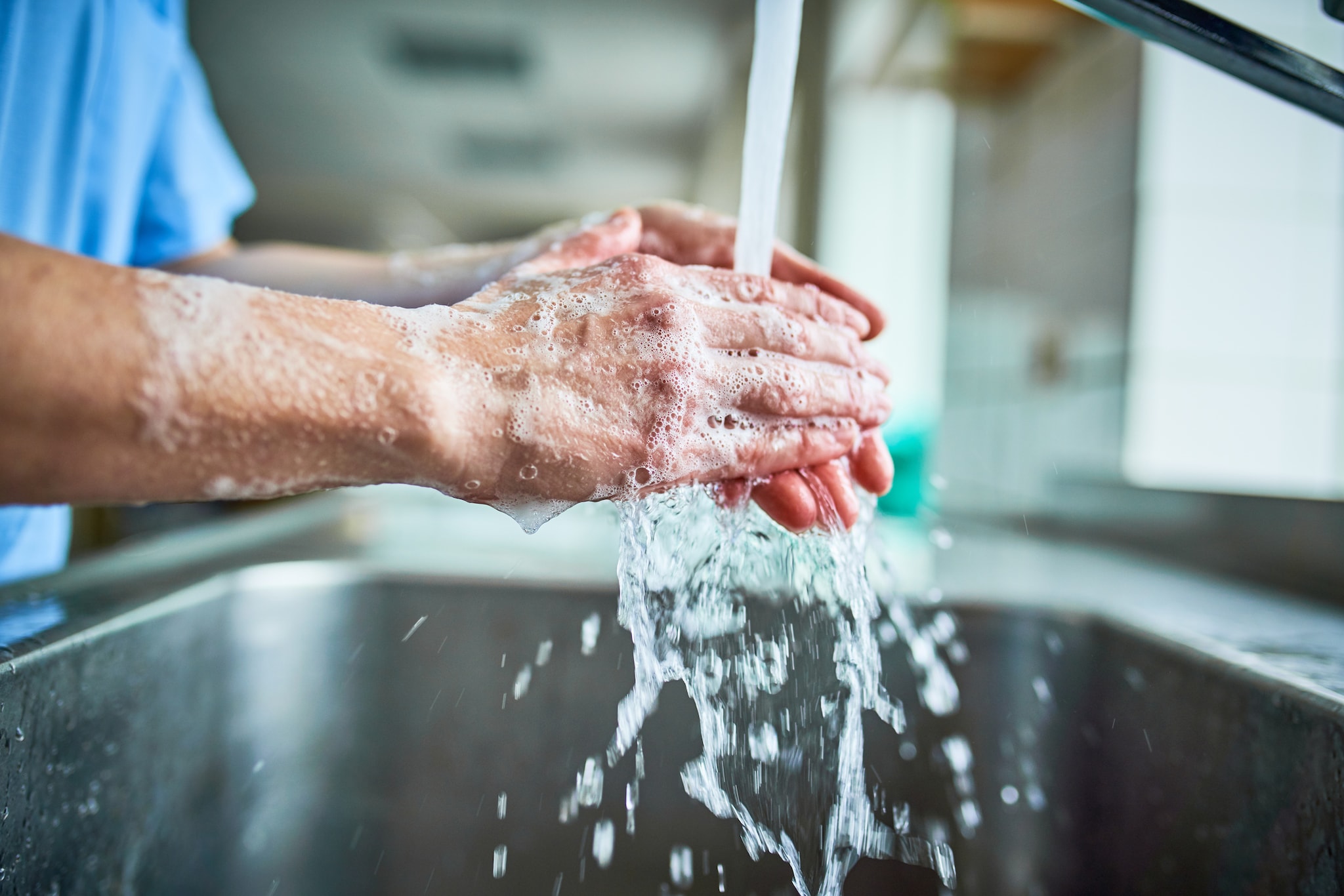 A healthcare worker washing hands with soap