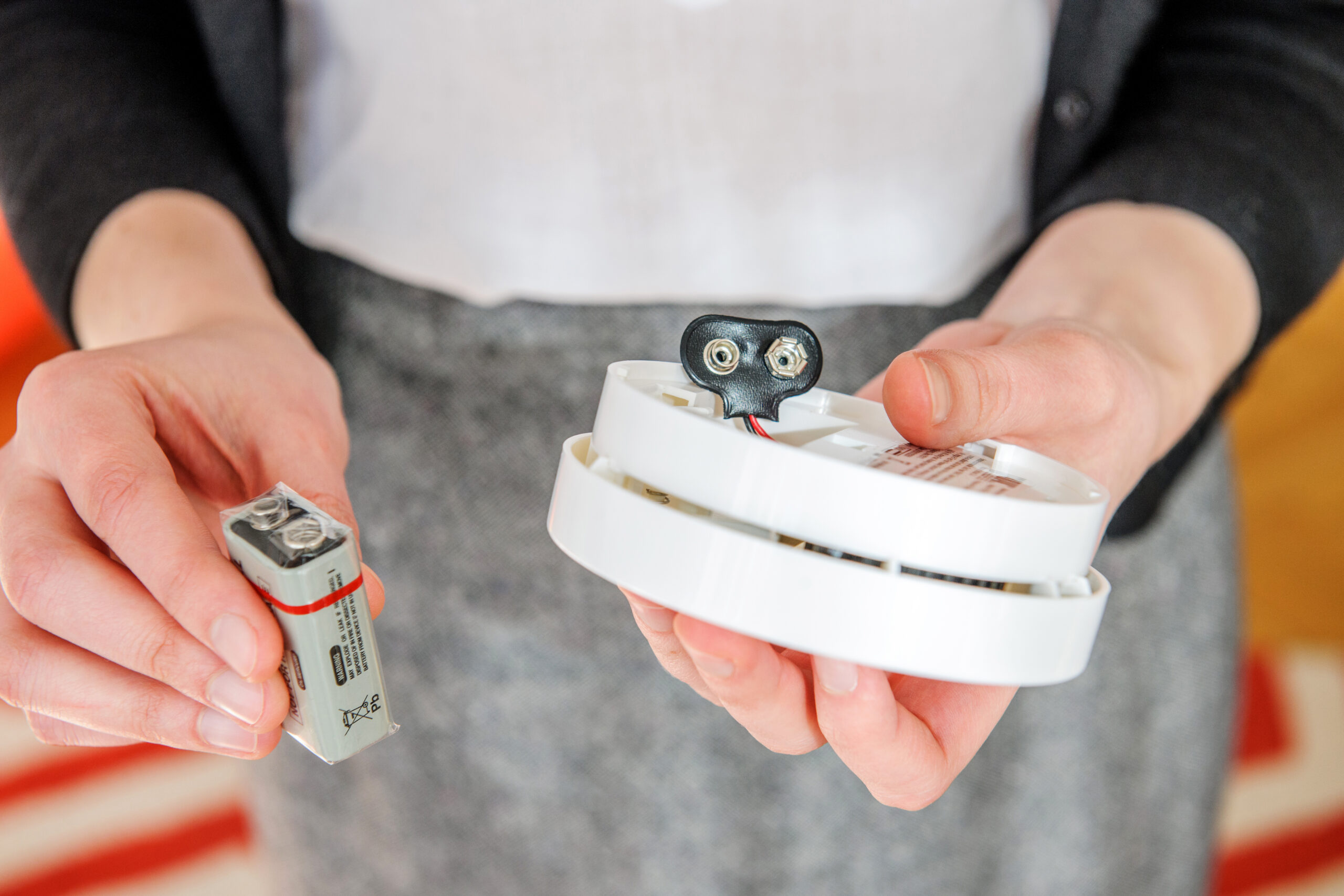 Person replacing the batteries in a carbon monoxide detector.