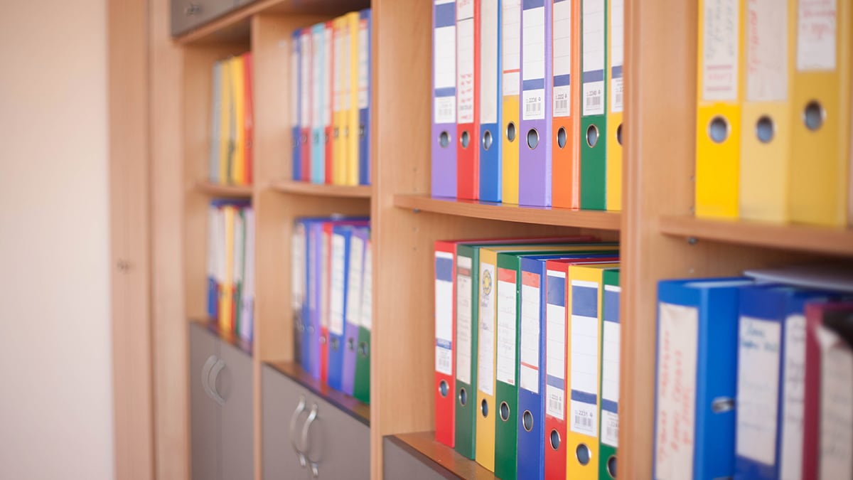 Shelves with rows of colorful files in office