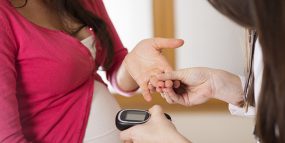 Picture of pregnant woman having sugar level tested by healthcare professional