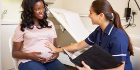 a pregnant woman speaking to a healthcare professional 
