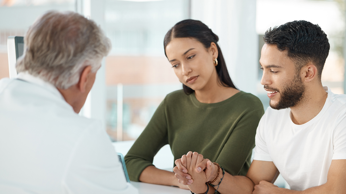 A young couple speaking with a doctor about pregnancy