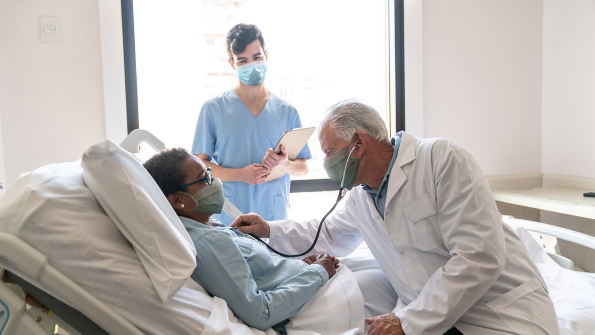 Photo of a cervical cancer patient in a hospital bed talking to her doctor