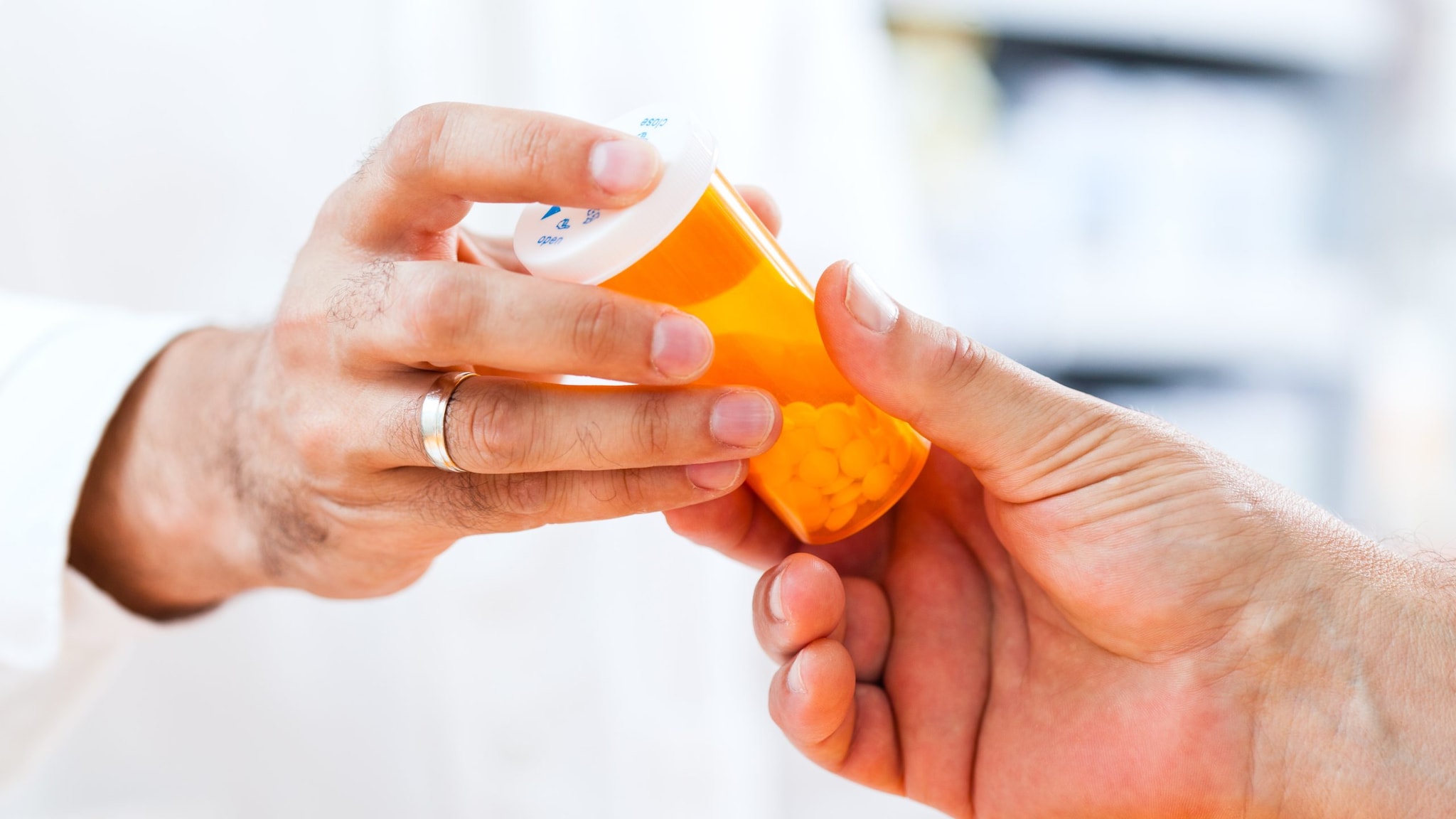 Doctor handing a patient a bottle of pills.
