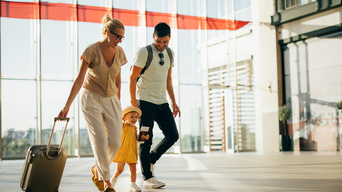 father walking his daughter on top of a suitcase