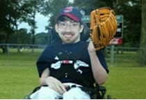 Zac posando en su silla de ruedas para su foto de equipo de béisbol.