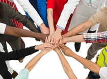 Photo of people with hands together.