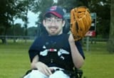 Zac posing in his wheel chair for his baseball team photo.