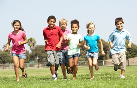 Photo of a group of school-age children running outside