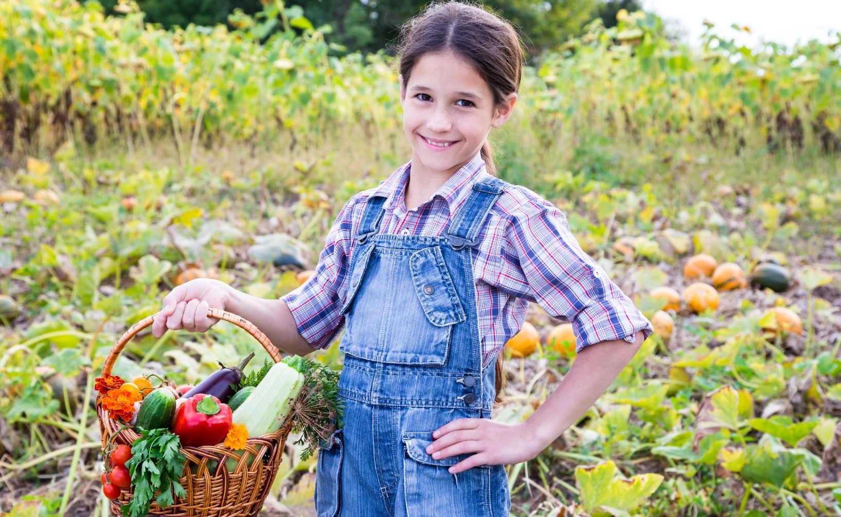 girl holding basket of vegetables