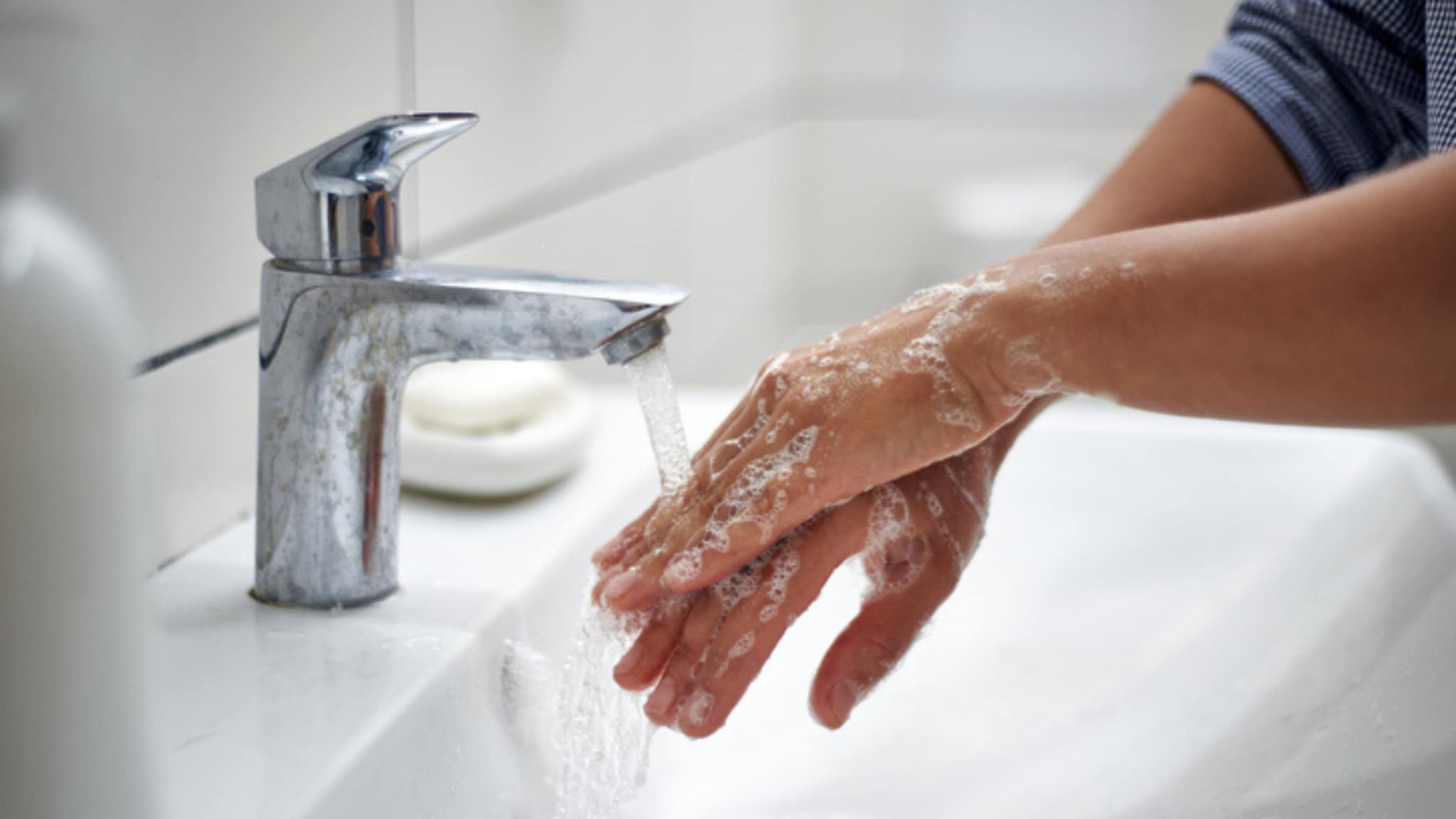 hands being washed in bathroom sink
