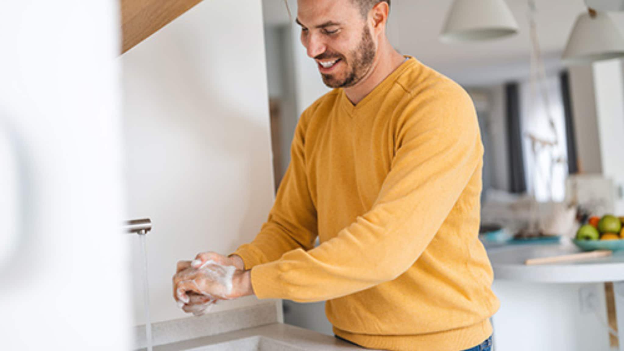 Man washing his hands in kitchen sink