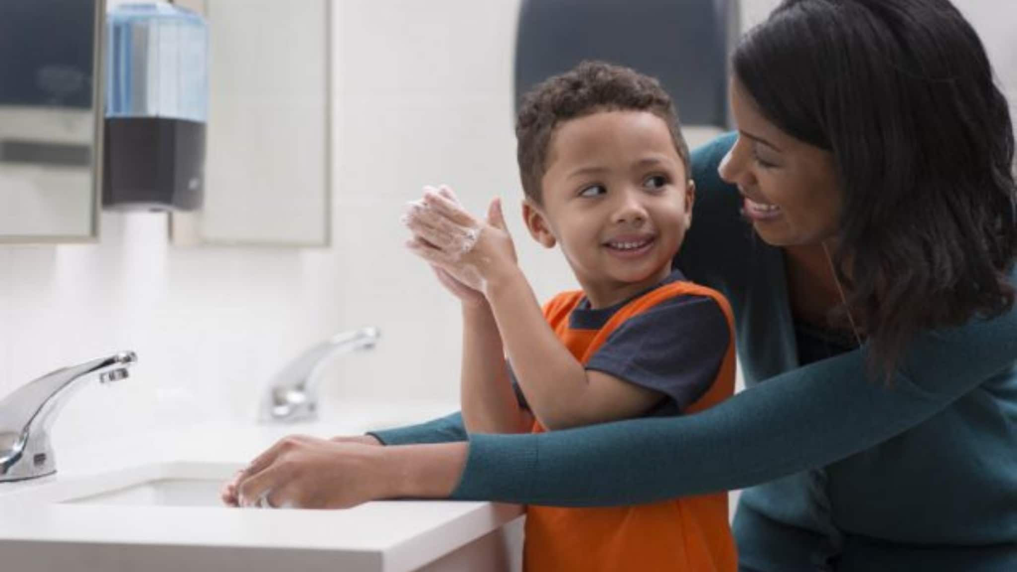woman and child washing hands in bathroom