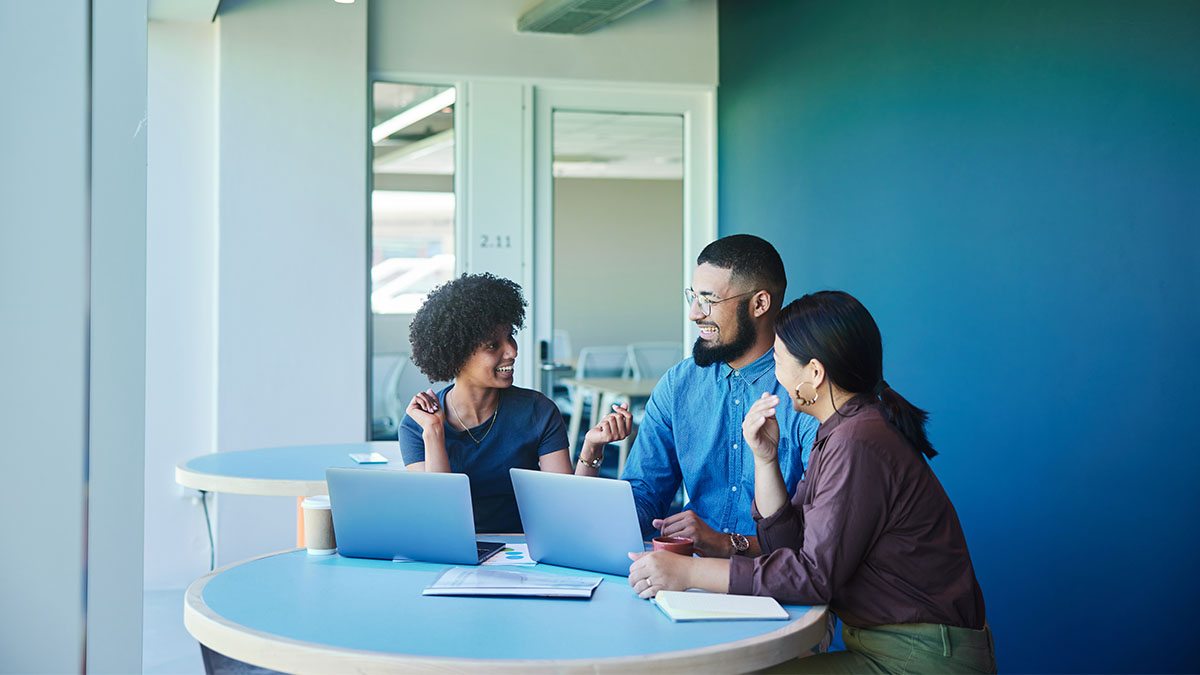 Diverse group of people working together during a meeting around a table in an office lounge.