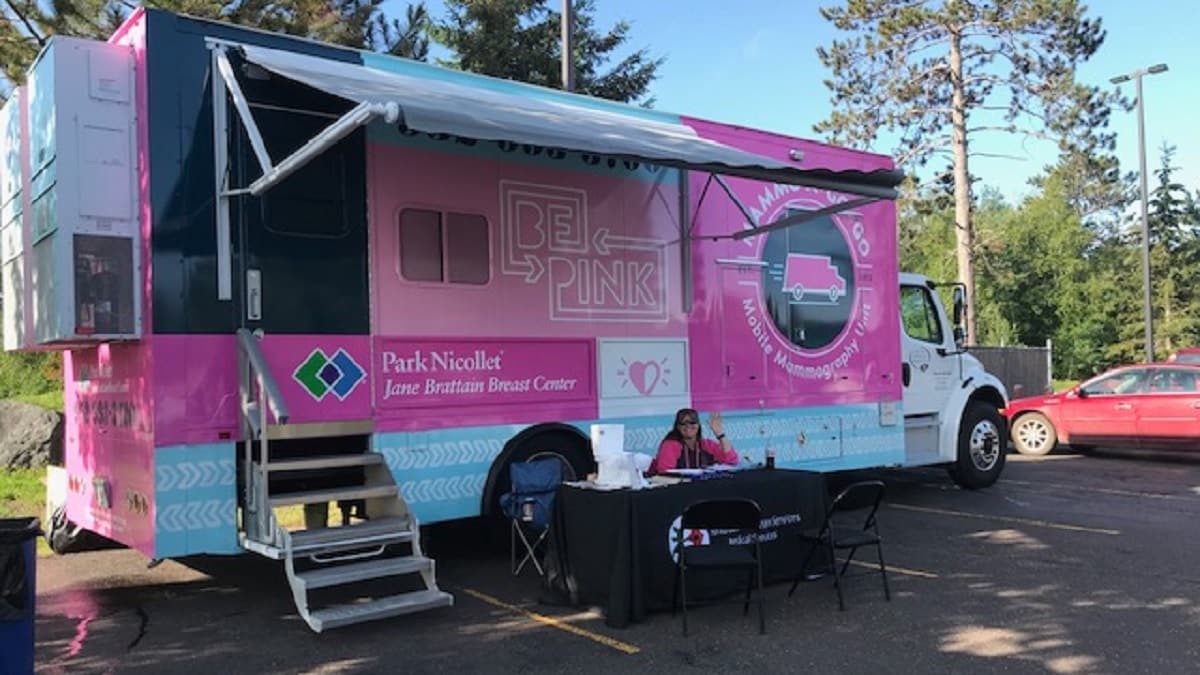 a health care worker in front of a Park Nicollet Mobile Mammography Unit