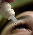 Person putting eyedrops in eyes