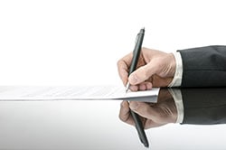 Person signing contract with pen.