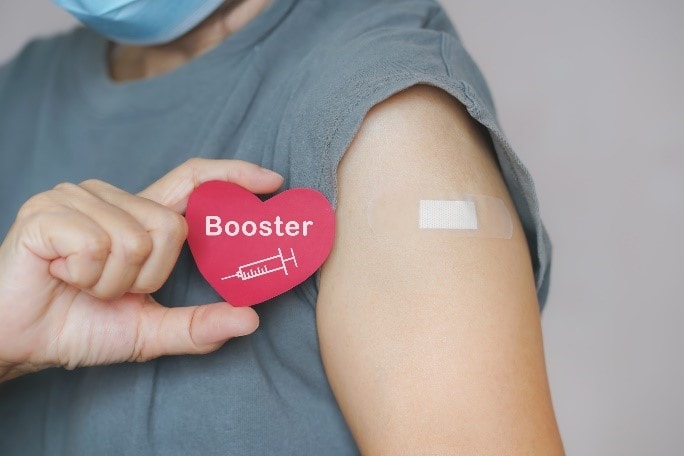 a bandaged shoulder, and a sticker reading "booster"