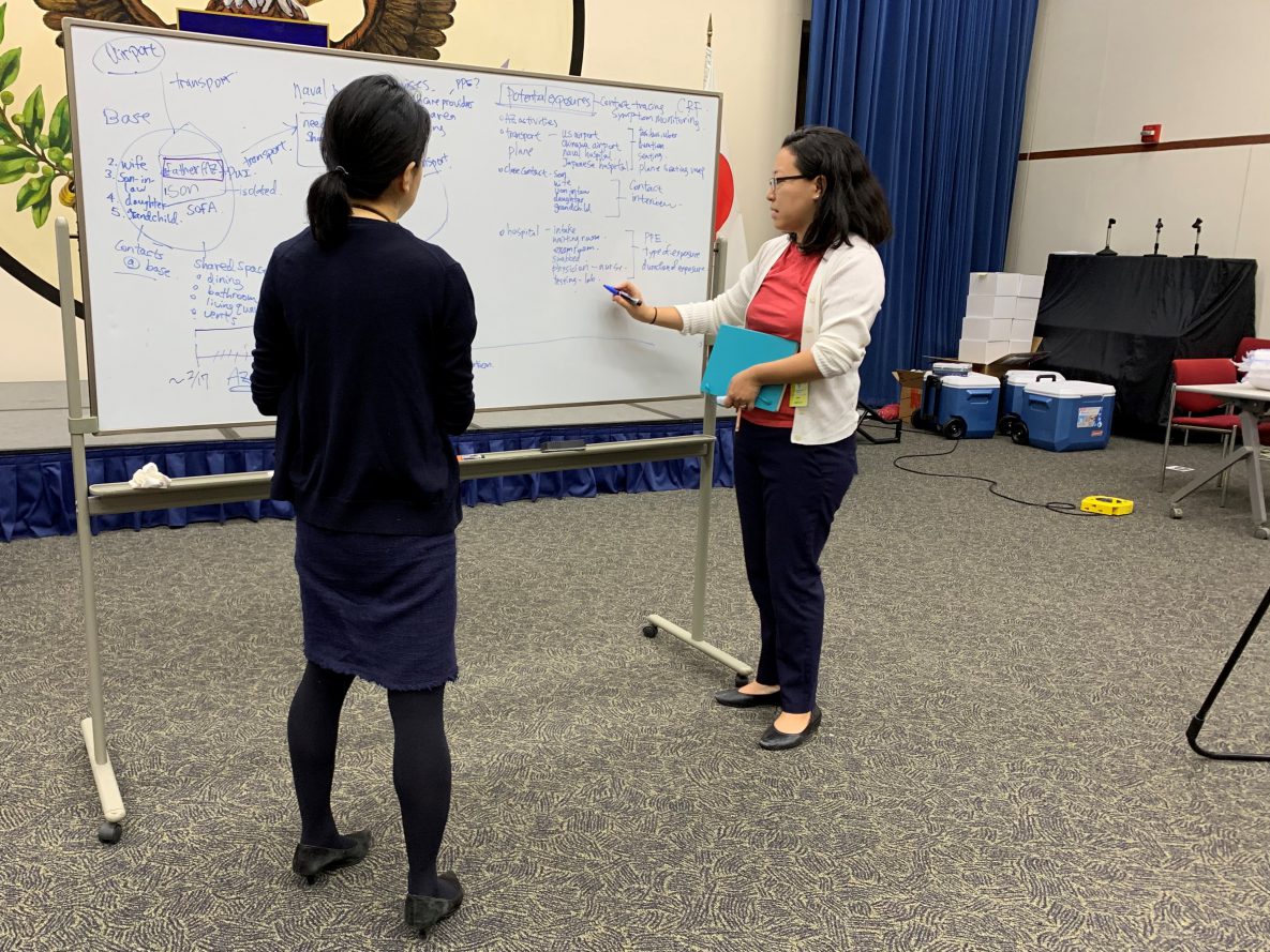 CDC epidemiologist Mitsuru Toda, right, and colleague Miwako Kobayashi lay out plans for potential cases of COVID-19 among Americans in Japan at the US Embassy in Tokyo in March. 