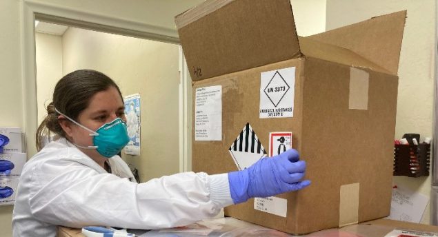 Jessica Prince-Guerra placing a label on a box of lab samples