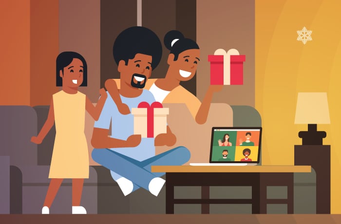 A family is shown indoors, holding presents, with a laptop in front of them. They are talking to other individuals who are shown on the laptop screen. 
