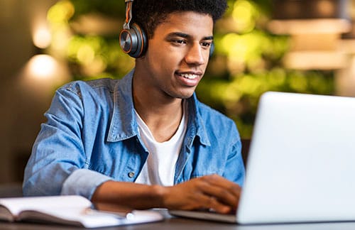 young man in headphones looking at laptop