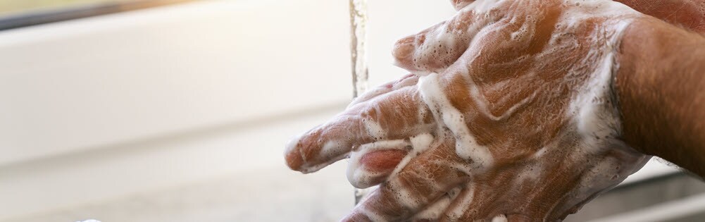 primer plano de un hombre lavándose las manos con agua y jabón