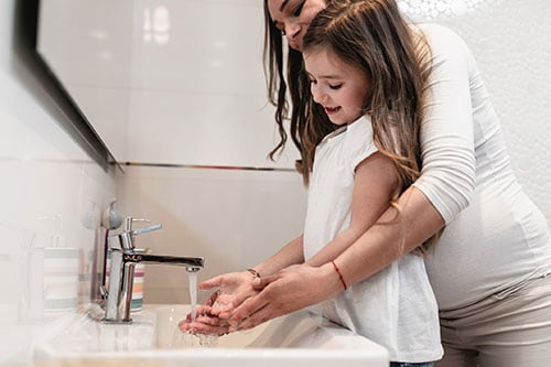 Madre e hija lavándose las manos