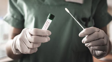 Healthcare worker holding vial and swab
