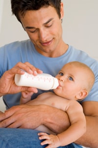 a man feeding baby formula