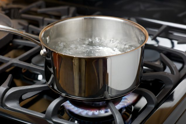 A pot filled with boiling water on a stove.