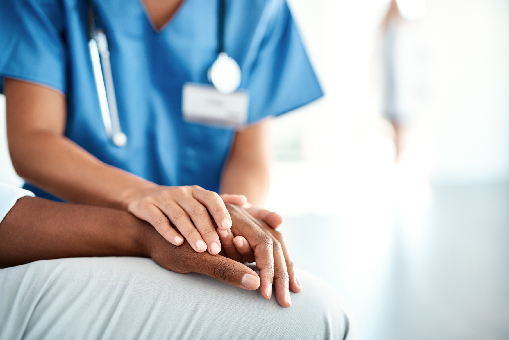 Close up of a doctor's hand on top of the hand of a patient.