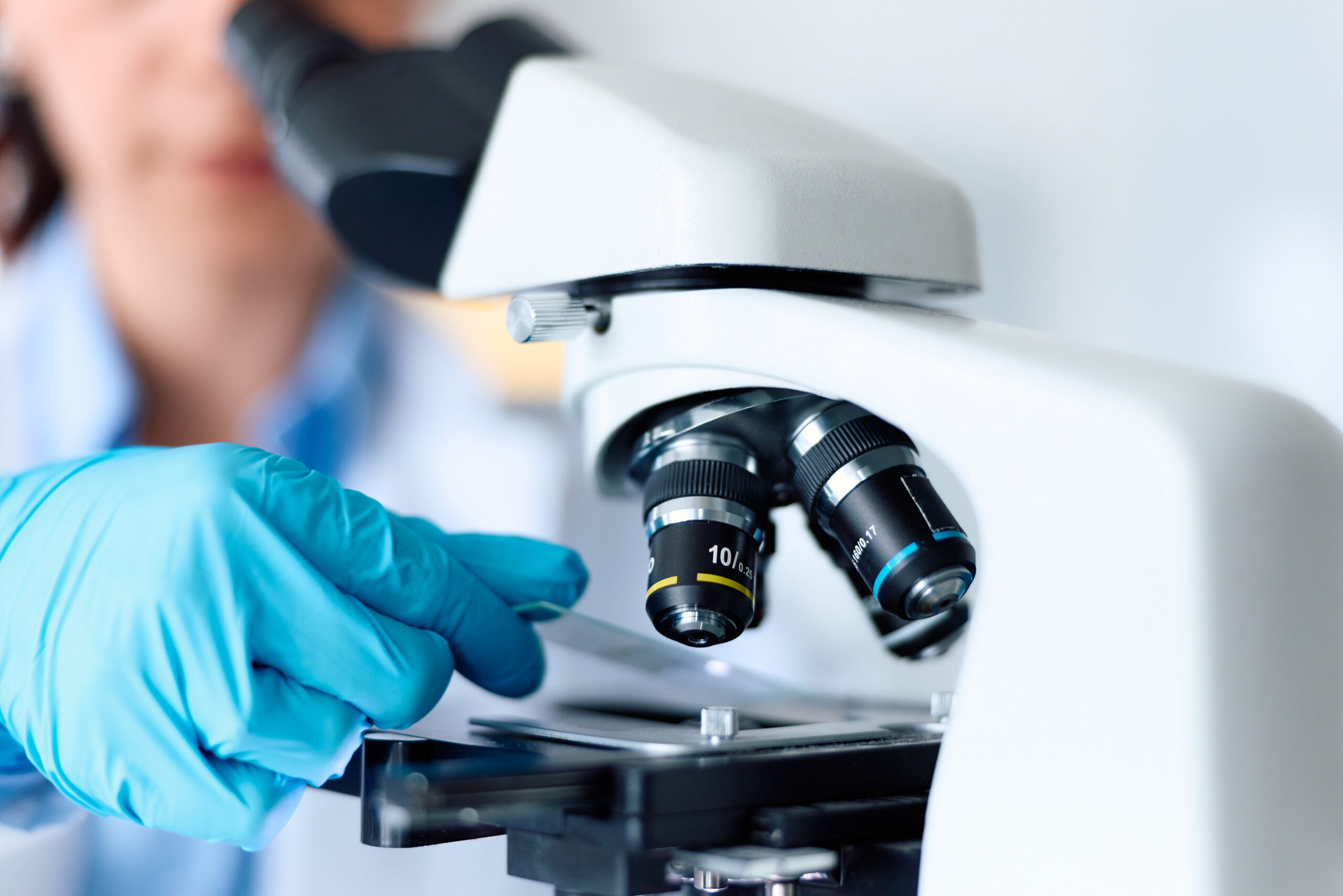 A laboratorian loads a slide into a microscope
