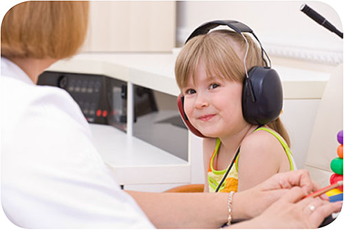 Young child receiving hearing checks from doctor.