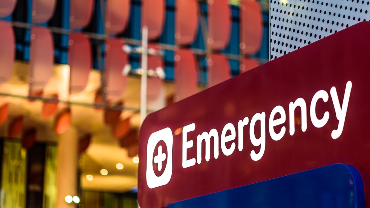 An imagine of an emergency room sign in front of a hospital.