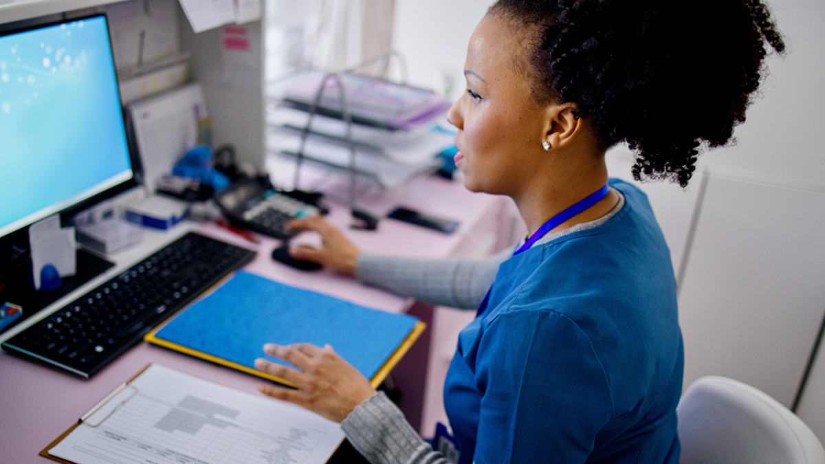 Healthcare provider working on a computer.