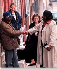 A CHW shaking a man's hand on the street.