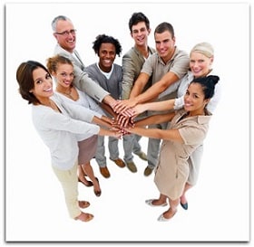 A group of people in a circle with their hands together in the middle.