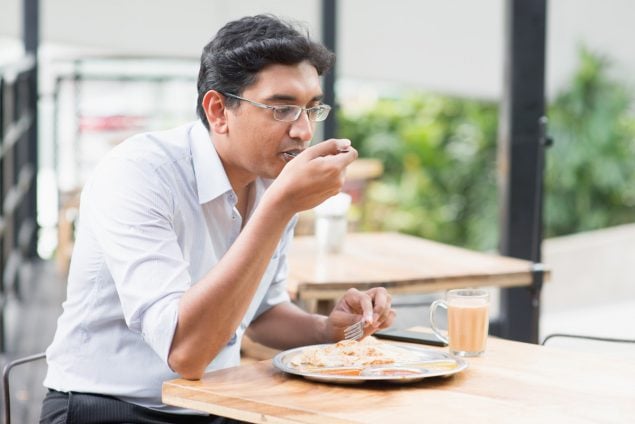 Indian business man eating lunch.