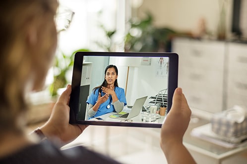 Woman holding a tablet during a video call.