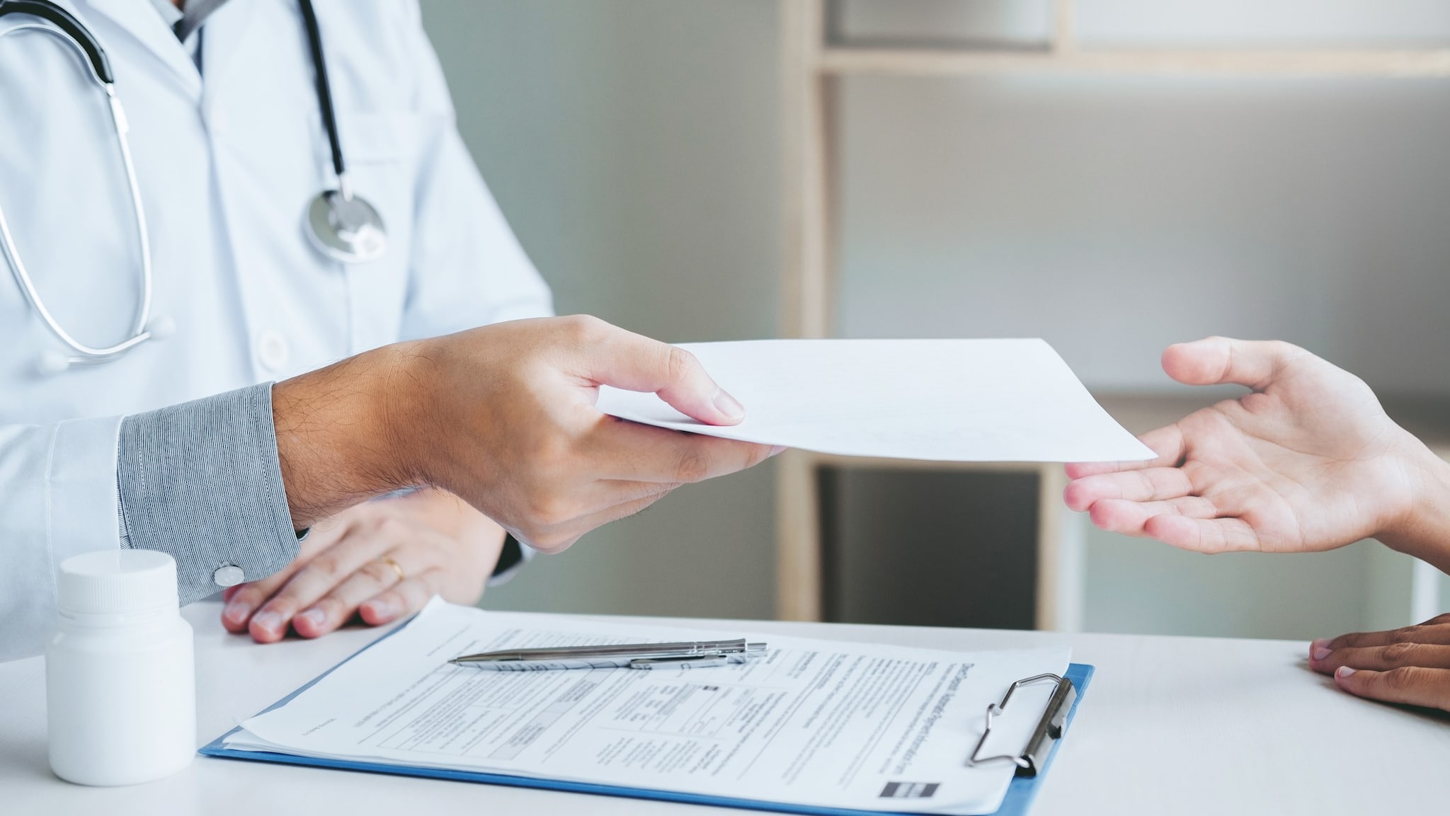 Doctor handing a patient a referral form