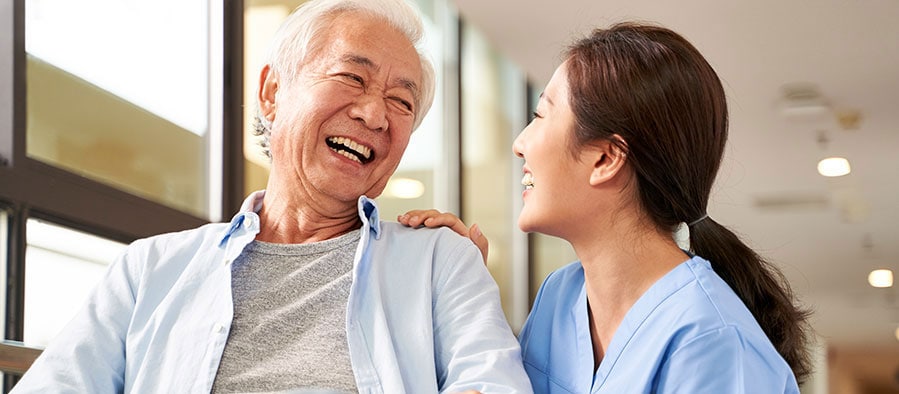 Woman nurse talking to smiling elderly man