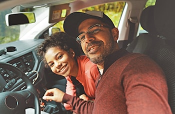 man and his daughter smiling in a car
