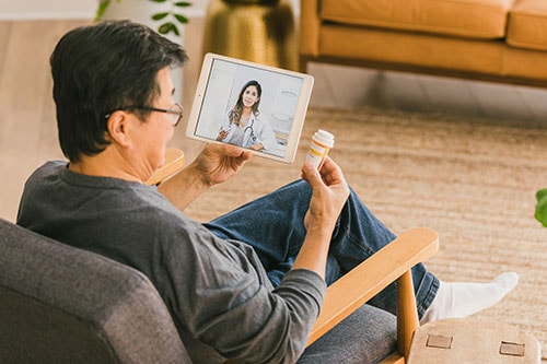 Mature man uses telehealth to talk to a health care provider about medicine
